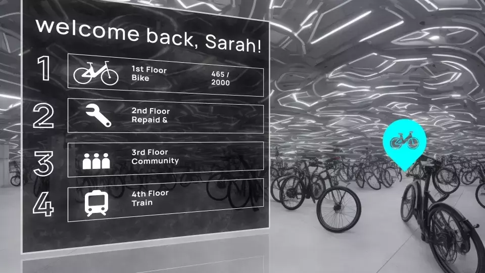 Digital directory showing bicycle parking facility with floor guide and welcome message, surrounded by parked bikes.