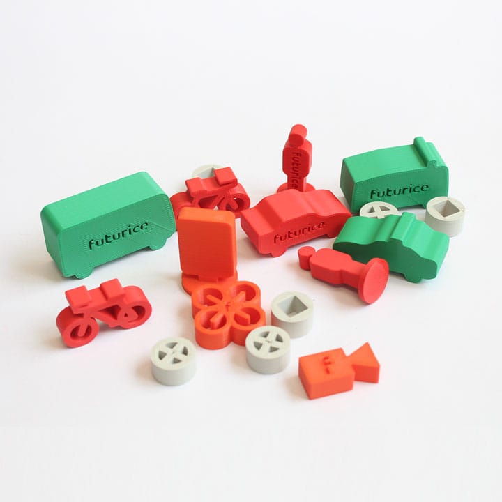Colourful 3D-printed toy vehicles and parts in green, red and orange, featuring miniature cars and trucks with "futurice" branding.