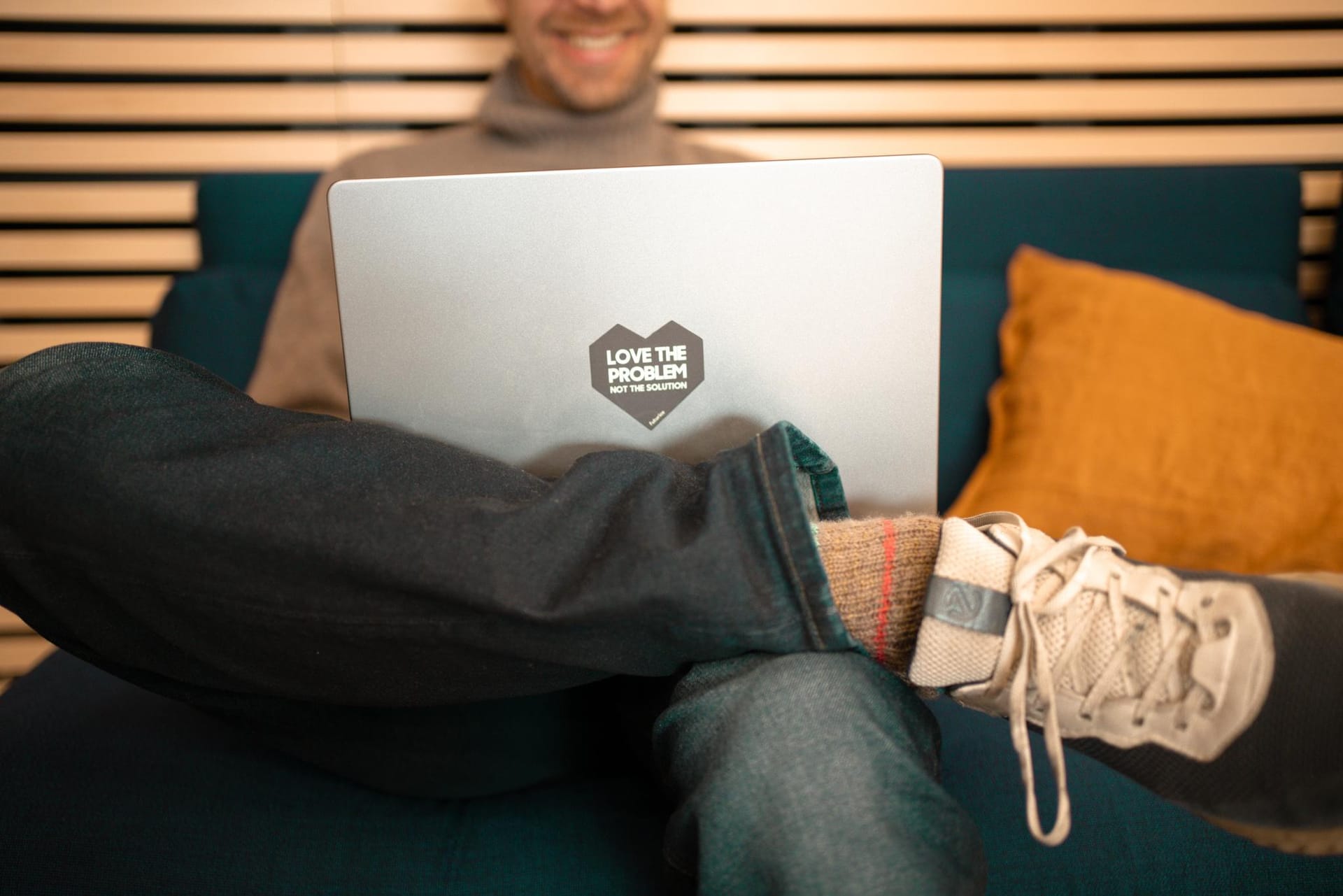 A person's laptop has a sticker with text Love the problem.